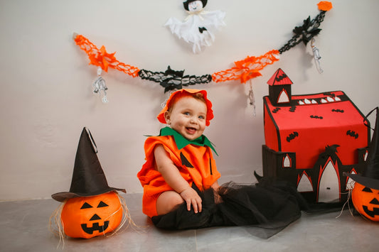 a young child in a halloween costume sitting on the floor