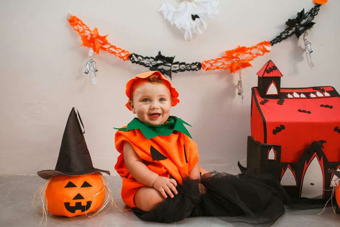 a baby in a halloween costume sitting on the floor
